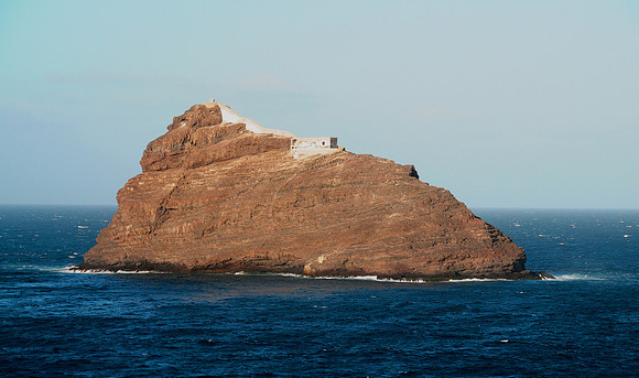 Volcanic outcrop in middle of sea outside the port - has some sort of structure on it