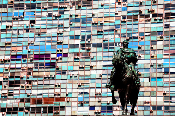 Apartment building behind statue of Artigas
